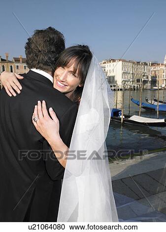 Italy, Venice, bride and groom embracing, woman smiling View Large Photo Image Stock Image - Italy, Venice, bride and groom embracing, woman smiling. Fotosearch