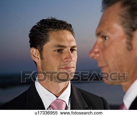 Stock Photography - Mature father and groom outdoors, close-up, dusk. Fotosearch
