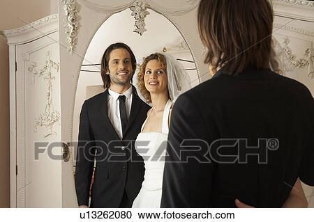 young bridal couple smiling at reflection in mirror View Large Photo Image Stock Image - young bridal couple smiling at reflection in mirror. Fotosearch