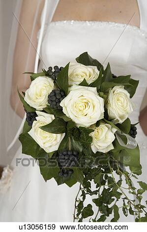 young bride holding bridal bouquet, mid section, close-up View Large Photo Image Stock Photo - young bride holding bridal bouquet, mid section, close-up. Fotosearch