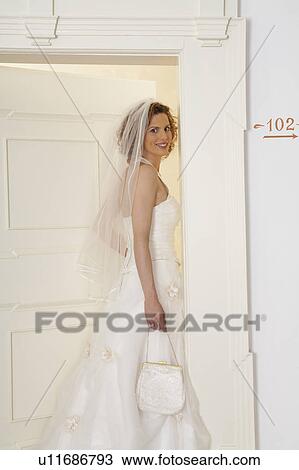 young bride opening door looking over shoulder, portrait View Large Photo Image Stock Image - young bride opening door looking over shoulder, portrait. Fotosearch