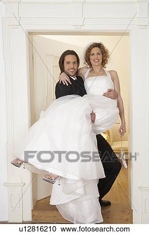 young groom carrying bride over threshold, portrait View Large Photo Image Stock Image - young groom carrying bride over threshold, portrait. Fotosearch