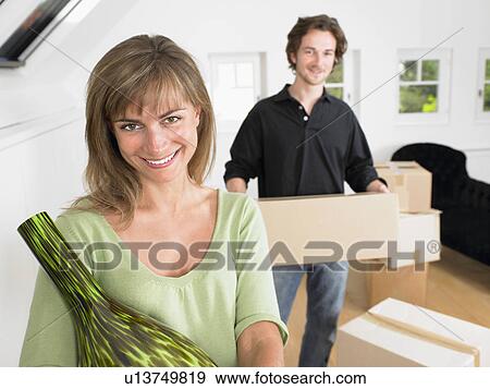 Couple moving into new home smiling. View Large Photo Image Stock Photo - Couple moving into new home smiling.. Fotosearch