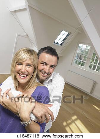 Happy couple holding each other into white empty loft. Portrait. View Large Photo Image Stock Photo - Happy couple holding each other into white empty loft. Portrait.. Fotosearch