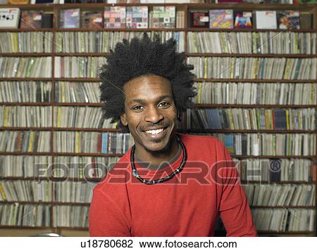 Stock Image - Man in music shop, smiling, portrait. Fotosearch