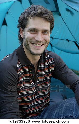 Man sitting in tent at campsite smiling. View Large Photo Image Stock Photograph - Man sitting in tent at campsite smiling.. Fotosearch