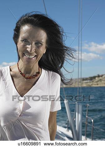 Mature woman standing on yacht, smiling, portrait View Large Photo Image Stock Image - Mature woman standing on yacht, smiling, portrait. Fotosearch