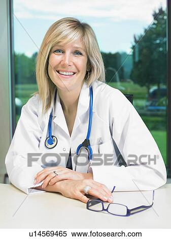 Portrait of smiling female doctor at her desk. View Large Photo Image Stock Photography - Portrait of smiling female doctor at her desk.. Fotosearch