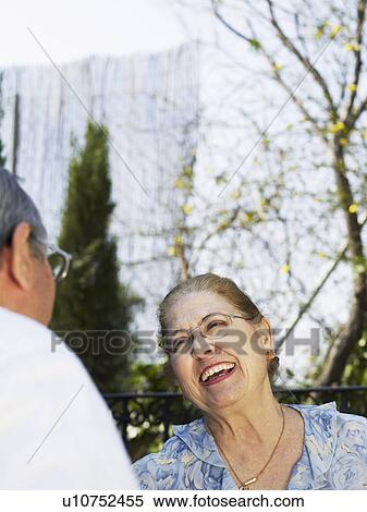 Stock Photography - Senior couple outdoors, woman laughing. Fotosearch