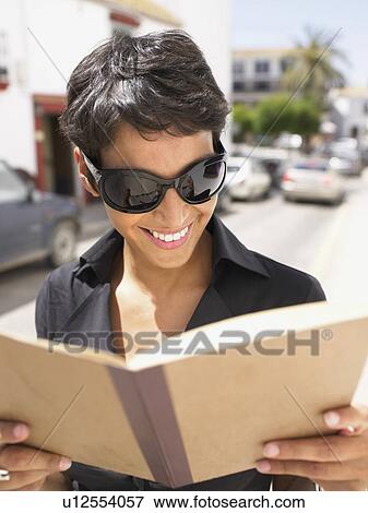 Stock Photo - Woman reading and smiling.. Fotosearch