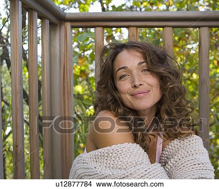 Woman sitting on balcony smiling. View Large Photo Image Picture - Woman sitting on balcony smiling.. Fotosearch
