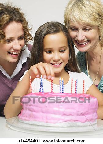 Stock Image - 3 generation females with birthday cake. Fotosearch