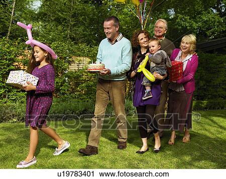 Stock Image - Family arriving with birthday cake. Fotosearch