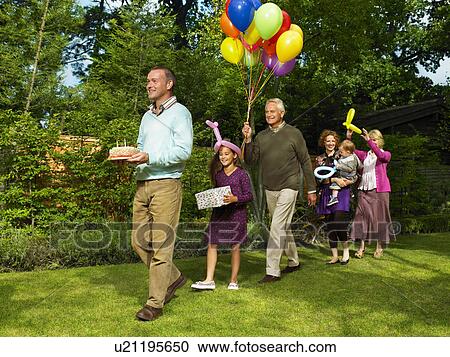 Stock Image - Family arriving with birthday cake. Fotosearch