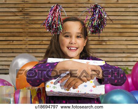 Stock Photo - Girl (8-10) holding birthday present. Fotosearch