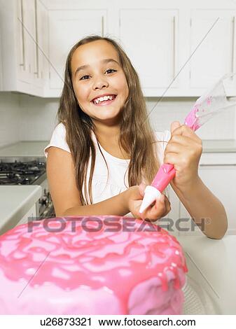 Girl (8-10) icing cake View Large Photo Image Stock Image - Girl (8-10) icing cake. Fotosearch