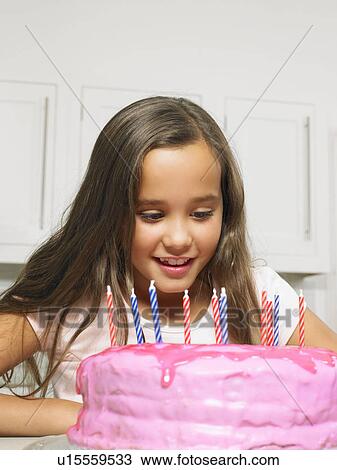 Girl (8-10) looking at cake with candles View Large Photo Image Stock Image - Girl (8-10) looking at cake with candles. Fotosearch
