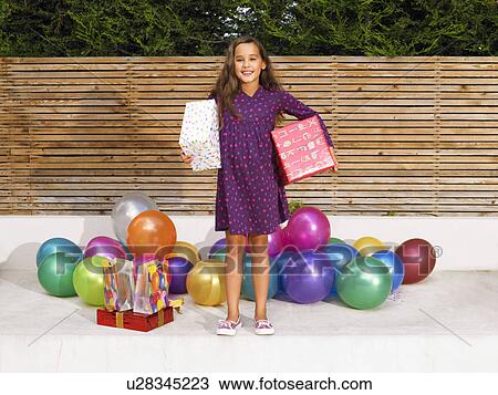 Girl (8-10) with presents and balloons View Large Photo Image Stock Image - Girl (8-10) with presents and balloons. Fotosearch