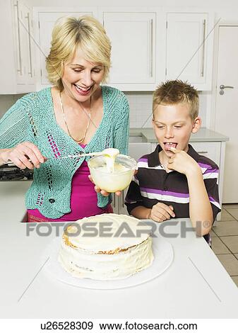 Senior woman and boy decorating cake View Large Photo Image Stock Photo - Senior woman and boy decorating cake. Fotosearch