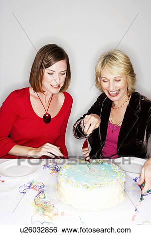 Two women cutting birthday cake View Large Photo Image Stock Photograph - Two women cutting birthday cake. Fotosearch