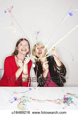 Two women with party poppers View Large Photo Image Stock Photograph - Two women with party poppers. Fotosearch