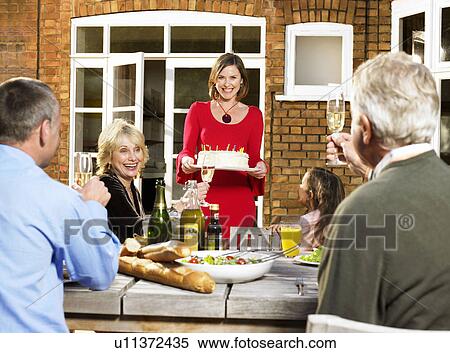 Woman carrying birthday cake to table View Large Photo Image Stock Photography - Woman carrying birthday cake to table. Fotosearch
