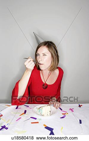 Stock Photo - Woman eating birthday cake. Fotosearch