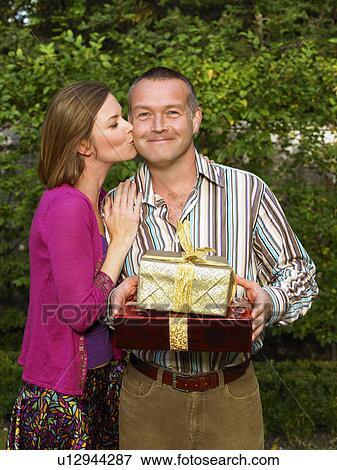 Woman kissing mature man on cheek View Large Photo Image Stock Photo - Woman kissing mature man on cheek. Fotosearch
