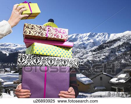 Young man holding pile of presents View Large Photo Image Stock Photography - Young man holding pile of presents. Fotosearch