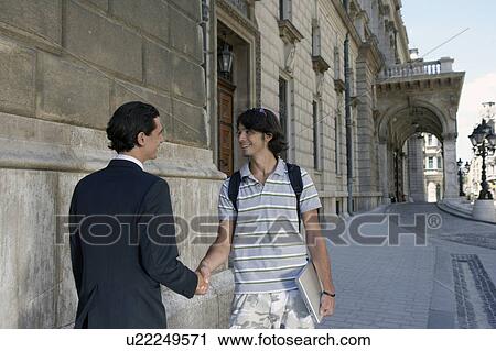 Businessman shaking hands with man outside opera house. View Large Photo Image Stock Image - Businessman shaking hands with man outside opera house.. Fotosearch