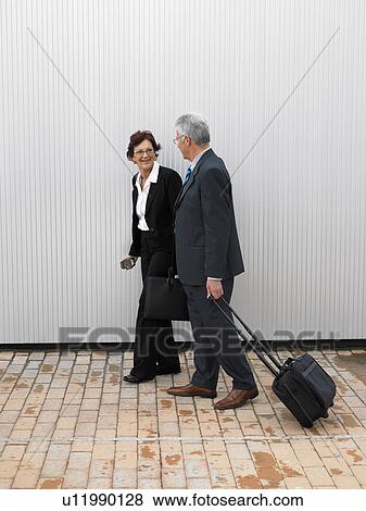 Stock Photo - Businesspeople by a silver wall.. Fotosearch