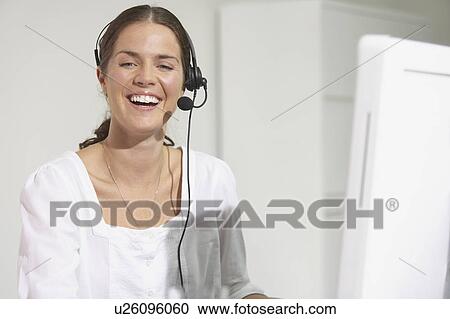 Smiling woman at computer desk using headset. View Large Photo Image Stock Image - Smiling woman at computer desk using headset.. Fotosearch