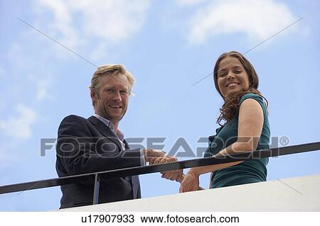 Young businessman and business woman on balcony. View Large Photo Image Stock Image - Young businessman and business woman on balcony.. Fotosearch
