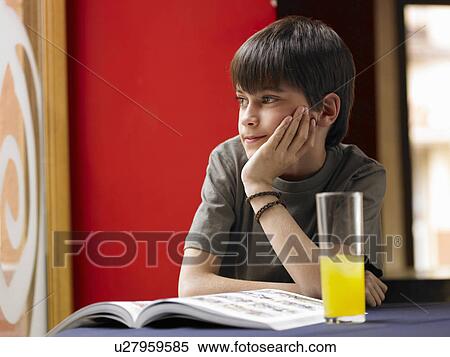 Boy (8-10) sitting at café table with hand on chin, daydreaming View Large Photo Image Stock Photography - Boy (8-10) sitting at café table with hand on chin, daydreaming. Fotosearch