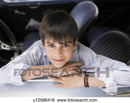 Boy (8-10) sitting in car, leaning out of open window, portrait View Large Photo Image Stock Photo - Boy (8-10) sitting in car, leaning out of open window, portrait. Fotosearch