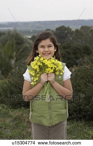 Picture - Girl (6-8) holding bunch of flowers, portrait. Fotosearch