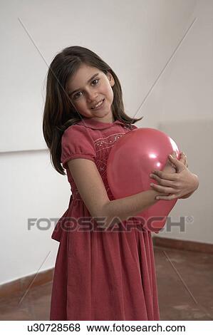Girl (9-11) holding red balloon, smiling, portrait View Large Photo Image Stock Photo - Girl (9-11) holding red balloon, smiling, portrait. Fotosearch