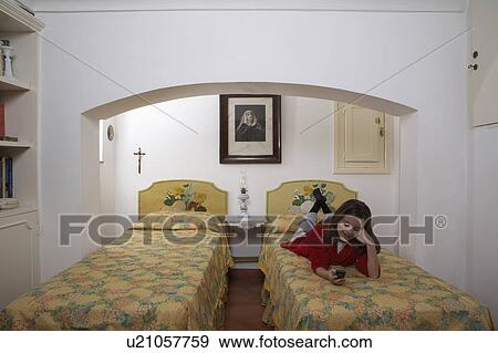 Girl (9-11) lying on bed using mobile phone View Large Photo Image Stock Photo - Girl (9-11) lying on bed using mobile phone. Fotosearch