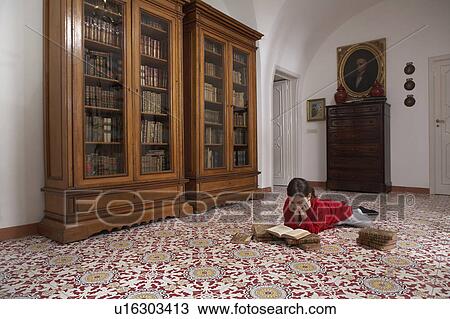 Girl (9-11) lying on floor reading books View Large Photo Image Stock Image - Girl (9-11) lying on floor reading books. Fotosearch