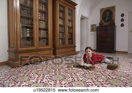 Girl (9-11) lying on floor reading books, portrait View Large Photo Image Stock Photography - Girl (9-11) lying on floor reading books, portrait. Fotosearch