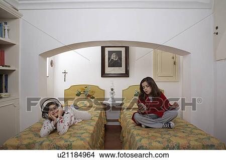 Picture - Girls (6-11) in bedroom wearing headphones. Fotosearch