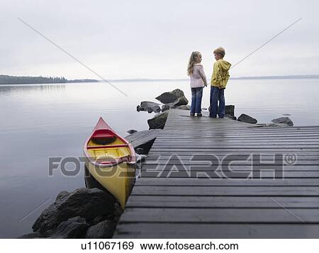 Young girl and young boy on a dock near a boat. View Large Photo Image Stock Photo - Young girl and young boy on a dock near a boat.. Fotosearch