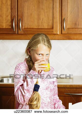 Young girl in kitchen drinking orange juice. View Large Photo Image Stock Photo - Young girl in kitchen drinking orange juice.. Fotosearch