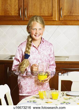 Young girl pouring orange juice into glasses smiling. View Large Photo Image Stock Photograph - Young girl pouring orange juice into glasses smiling.. Fotosearch