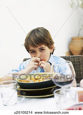 Boy (4-6) eating spaghetti at lunch in garden, portrait View Large Photo Image Picture - Boy (4-6) eating spaghetti at lunch in garden, portrait. Fotosearch