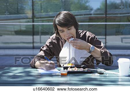 Businessman eating sushi and doing work while outside. View Large Photo Image Stock Image - Businessman eating sushi and doing work while outside.. Fotosearch