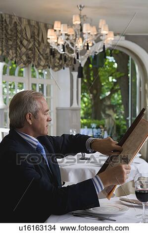 Businessman looking at watch in a restaurant View Large Photo Image Picture - Businessman looking at watch in a restaurant. Fotosearch