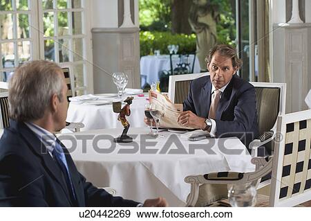 Two businessmen having lunch separately View Large Photo Image Stock Photo - Two businessmen having lunch separately. Fotosearch