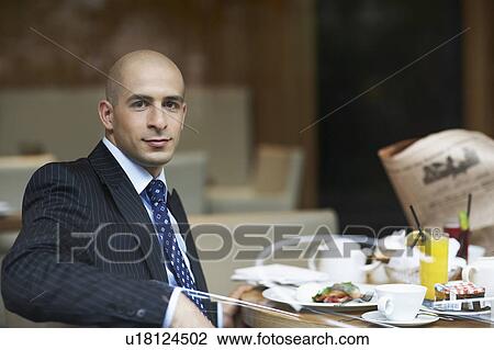Stock Image - A businessman in a restaurant. Fotosearch