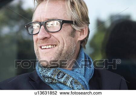 Businessman wearing extravagant scarf leaning against window with glasses. View Large Photo Image Stock Image - Businessman wearing extravagant scarf leaning against window with glasses.. Fotosearch